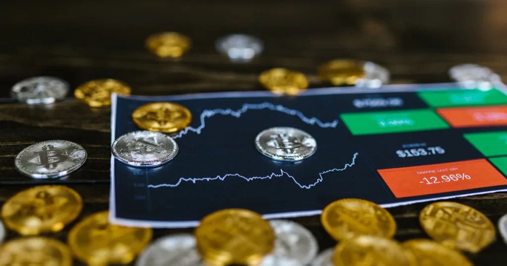 Bitcoin price chart with gold and silver crypto coins representing Crypto Card solutions and EMI service integration